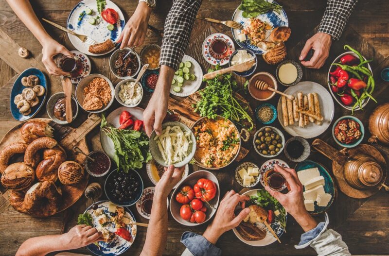 Een uitnodigende tafel vol diverse gerechten en ingrediënten voor een gezellige maaltijd met vrienden of familie.
